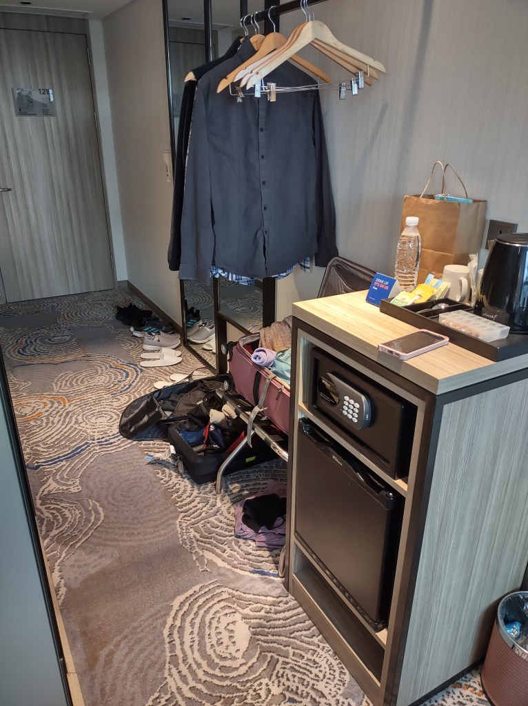 Small entry way with clothing rack, safe, minifridge.